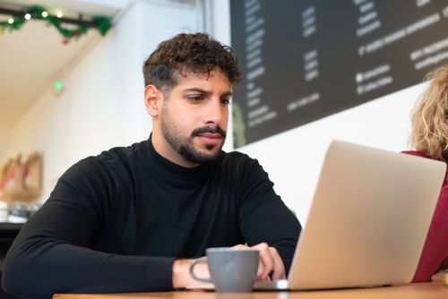 Founder working on a laptop at a cafe table